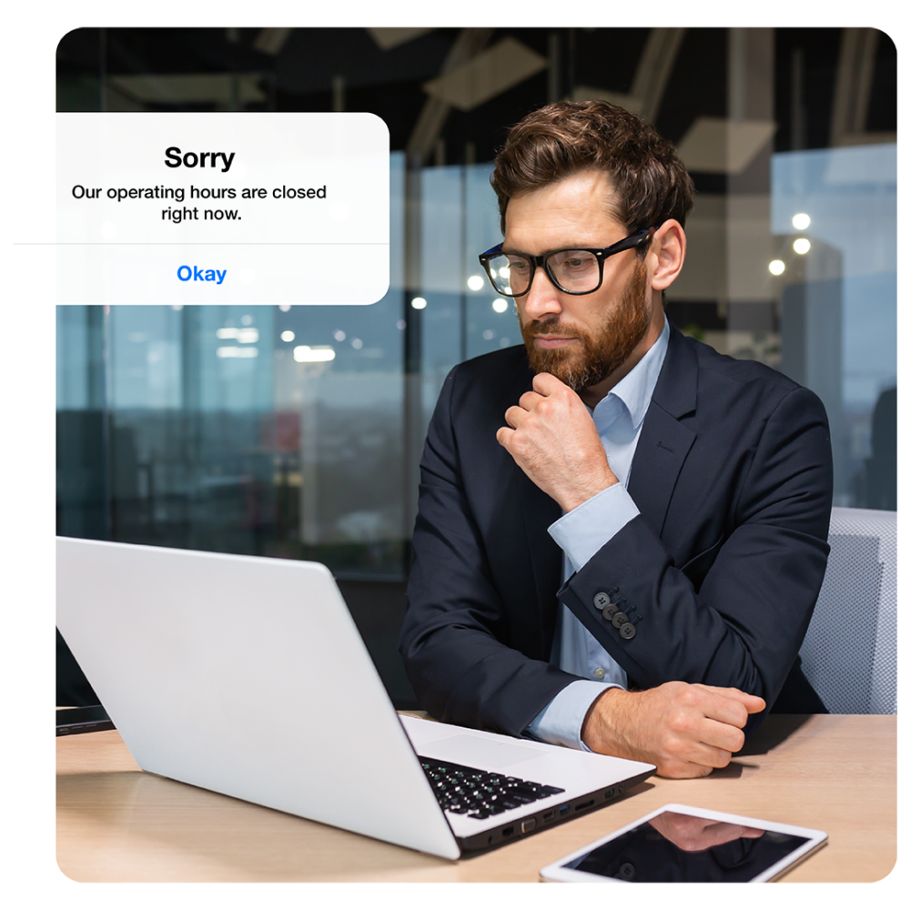 Man in suit at desk with laptop showing notification